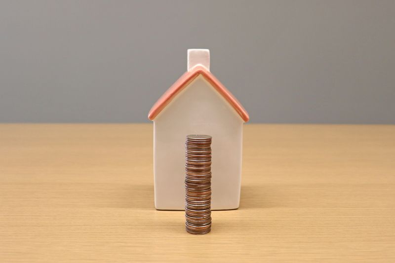a miniature house and a stack of coins